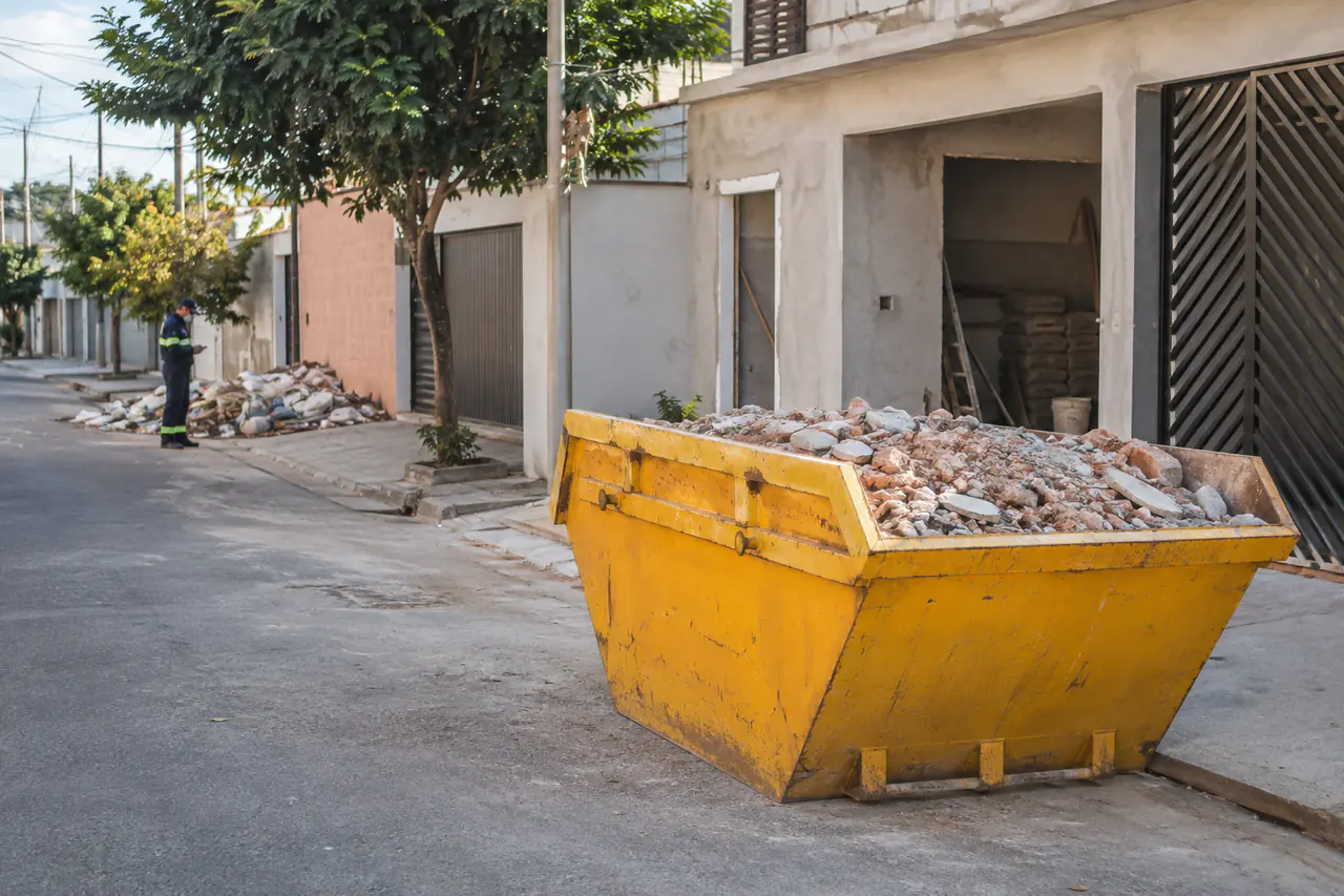 Caçamba amarela com entulho de obra armazenado corretamente em Santo André